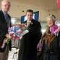 Richmond Vice Mayor Tom Butt presents flowers to Mariam Sauer, an original Rosie the Riveter, at a Veterans Day event at the SS Red Oak Victory, Nov. 11, 2011.